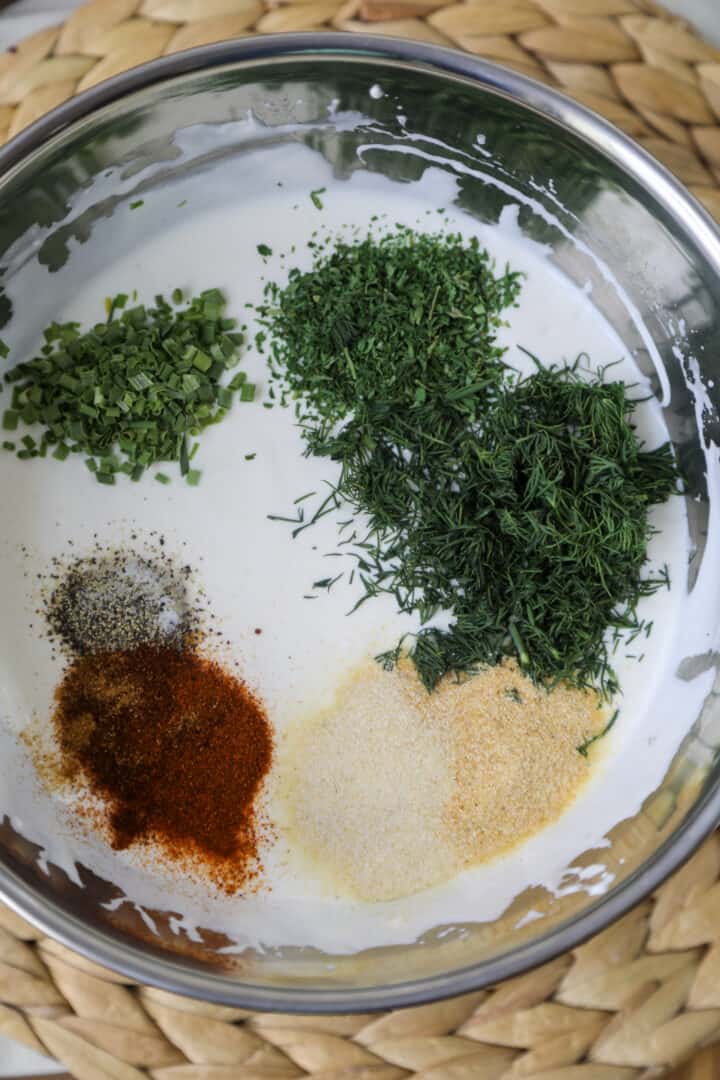 herbs and spices inside bowl with buttermilk mixture