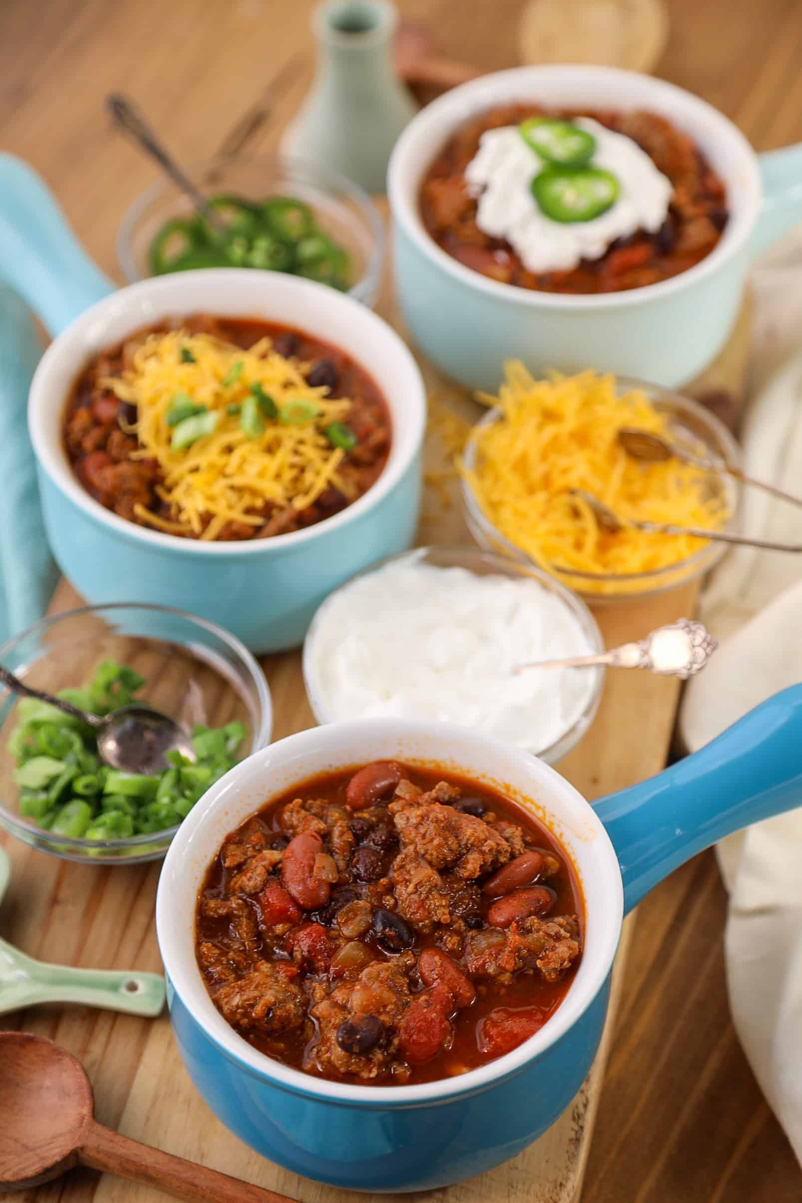 three bowls of chili with toppings