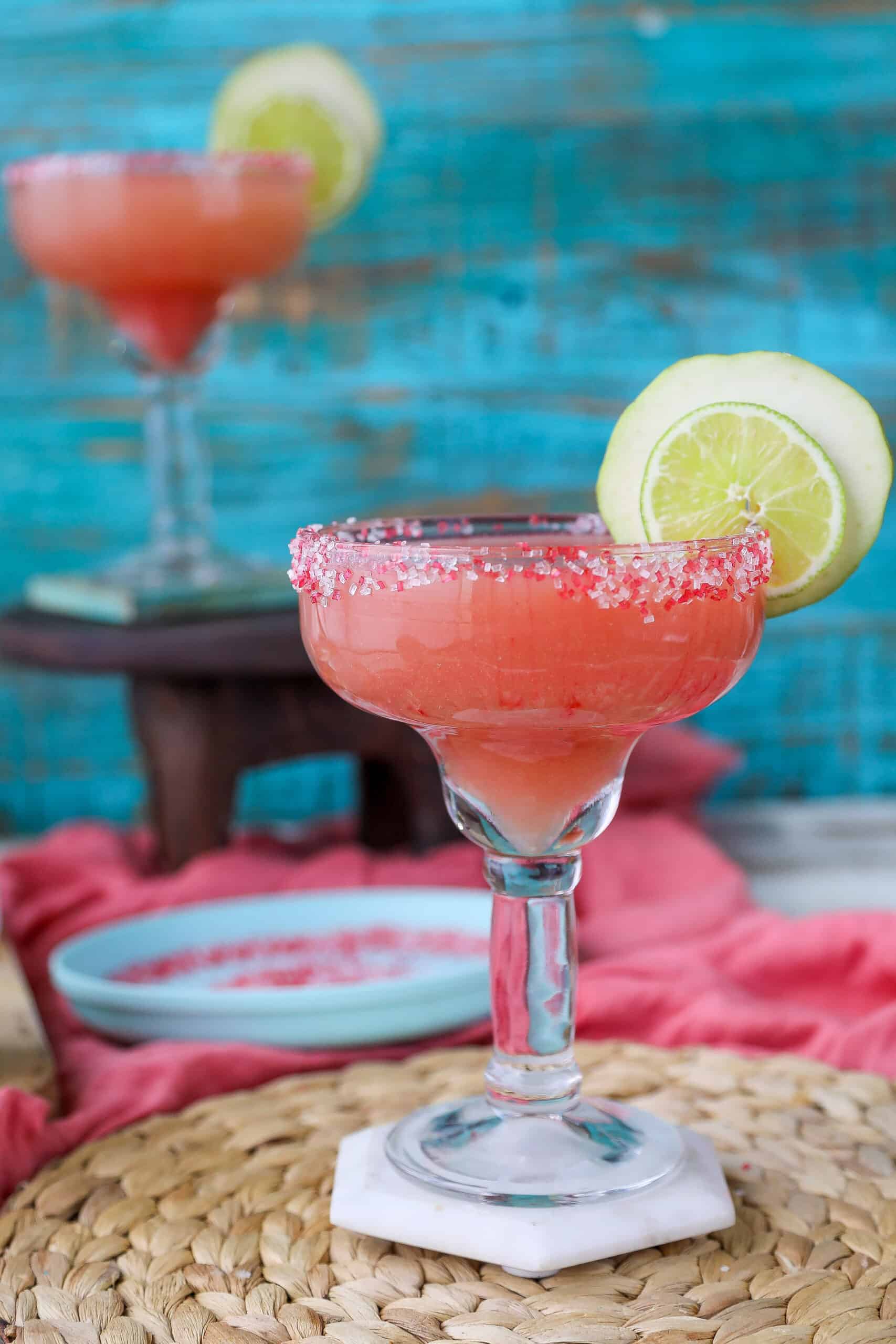two margarita glasses filled with guava margaritas